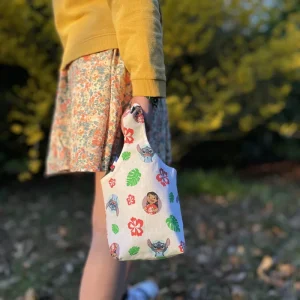 Image d’un sac panier réversible pour Pâques avec oreilles de lapin, côté coton Lilo et Stitch et côté jean denim, utilisé pour la chasse aux œufs ou comme pot à crayons.