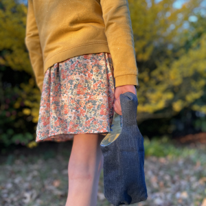 Image d’un sac panier réversible pour Pâques avec oreilles de lapin, côté coton pastel et côté jean denim, utilisé pour la chasse aux œufs ou comme pot à crayons.