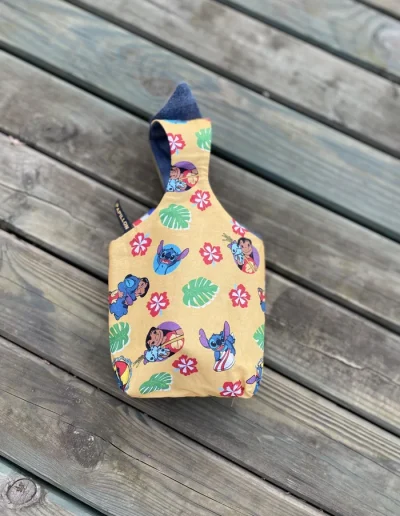 Image d’un sac panier réversible pour Pâques avec oreilles de lapin, côté coton Lilo et Stitch et côté jean denim, utilisé pour la chasse aux œufs ou comme pot à crayons.